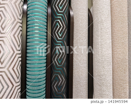 A neat row of wallpaper rolls in different textures and finishes, ideal for anyone looking to redecorate their walls with style A neat row of wallpaper rolls in different textures and finishes, ideal for anyone looking to redecorate their walls with style 141945594