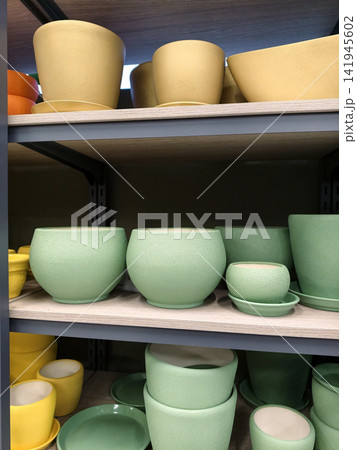 Blue ceramic plant containers with saucers in large and small sizes arranged neatly on shelves in a home improvement store Blue ceramic plant containers with saucers in large and small sizes arranged neatly on shelves in a home improvement store 141945602