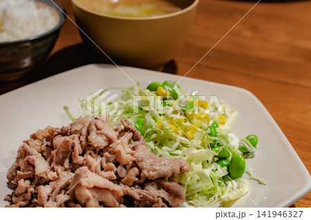 豚肉の炒め物とキャベツ、枝豆、漬物の定食 141946327