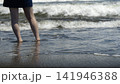 波打ち際に立つ水着姿の女性の足元 141946388