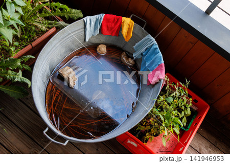 Colorful microfiber kithcen cleaning cloths on galvanized water tub on the balcony Colorful microfiber kithcen cleaning cloths on galvanized water tub on the balcony 141946953