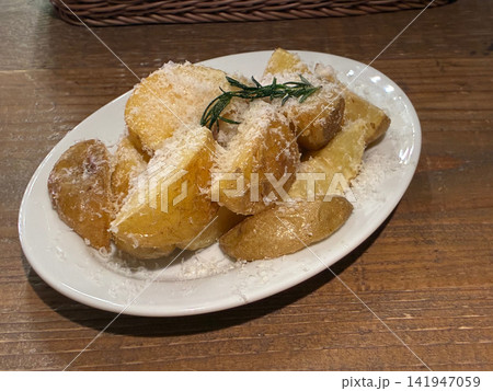 粉チーズとローズマリーを添えた厚切りポテトフライ 粉チーズとローズマリーを添えた厚切りポテトフライ 141947059
