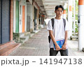 アーケードの下で参考書を持って立つ男子中学生 141947138
