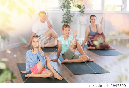 Family with two children doing yoga in studio Family with two children doing yoga in studio 141947760