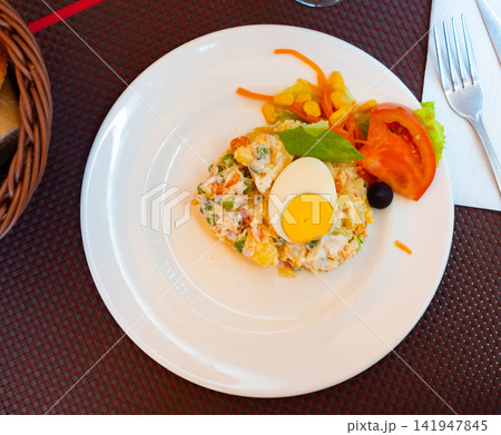 Appetizing Olivier salad with eggs, greens, vegetables, lettuce. Spanish cuisine Appetizing Olivier salad with eggs, greens, vegetables, lettuce. Spanish cuisine 141947845