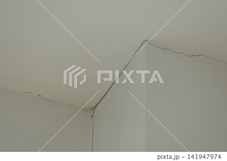 crack of pole on white wall from earthquake, construction industry 141947974