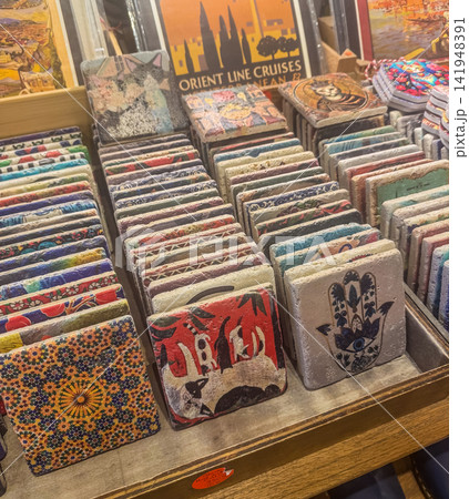 Colorful stone coasters featuring traditional Turkish patterns, hamsa hands, evil eyes, and cats displayed at a souvenir shop.. High quality photo Colorful stone coasters featuring traditional Turkish patterns, hamsa hands, evil eyes, and cats displayed at a souvenir shop.. High quality photo 141948391