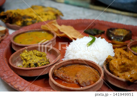 Traditional Bengali meal platter served in terracotta bowls with rice curry fish and side dishes Traditional Bengali meal platter served in terracotta bowls with rice curry fish and side dishes 141949951