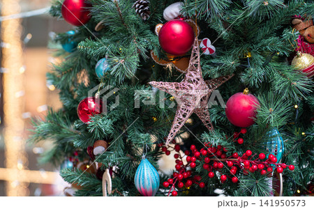 Colorful christmas deco and ornaments of balls and star hanging on tree. 141950573