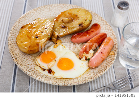 Fried sausages with potato and eggs Fried sausages with potato and eggs 141951305