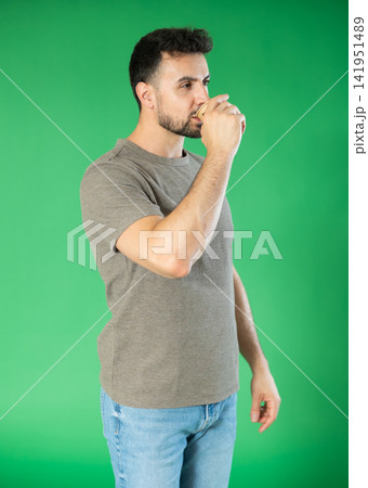 Adult man drinking coffee in front of green screen 141951489