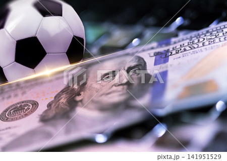 Sport bet on soccer game with money and a soccer ball placed on a table Sport bet on soccer game with money and a soccer ball placed on a table 141951529