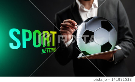 Sport betting with soccer ball and tablet in hands of a man in suit Sport betting with soccer ball and tablet in hands of a man in suit 141951538