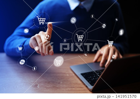 Online shopping using a laptop at home with a person pointing at a digital shopping cart icon 141951570