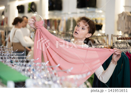 Adult woman choosing scarf in store Adult woman choosing scarf in store 141951651