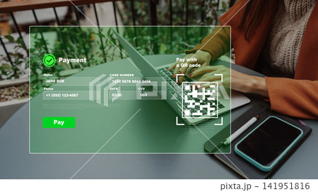Person making an online payment using a laptop with a QR code on the screen and a phone nearby Person making an online payment using a laptop with a QR code on the screen and a phone nearby 141951816