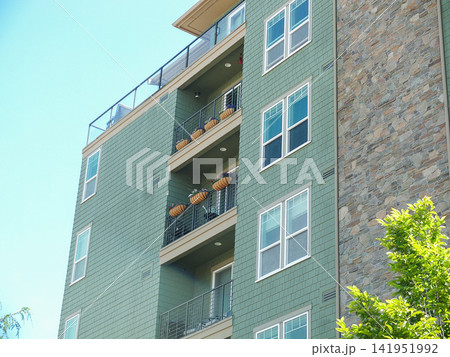 Close up of a modern green apartment building facade with balconies and stone siding in Ruston. - June 13, 2026 Ruston WA, USA Close up of a modern green apartment building facade with balconies and stone siding in Ruston. - June 13, 2026 Ruston WA, USA 141951992