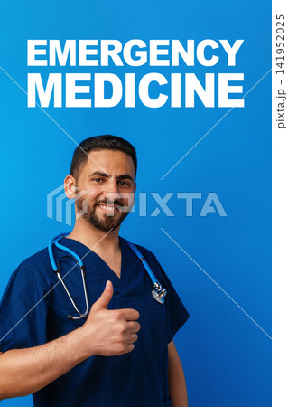 Emergency medicine professional gives a thumbs up in a blue setting during an awareness campaign on emergency 911 services 141952025