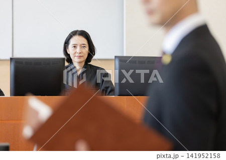 法廷で審理を行う女性裁判官と弁論する弁護士 法廷で審理を行う女性裁判官と弁論する弁護士 141952158