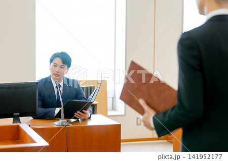法廷で弁護士の弁論を見つめる検察官 法廷で弁護士の弁論を見つめる検察官 141952177