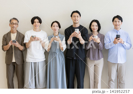 スマートフォンを操作する多世代の日本人グループポートレート 141952257