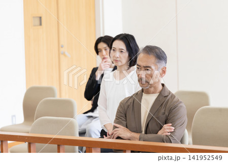 法廷の傍聴席で裁判を見守る真剣な傍聴人たち 法廷の傍聴席で裁判を見守る真剣な傍聴人たち 141952549