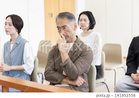 法廷の傍聴席で裁判を見守る真剣な傍聴人たち 法廷の傍聴席で裁判を見守る真剣な傍聴人たち 141952556