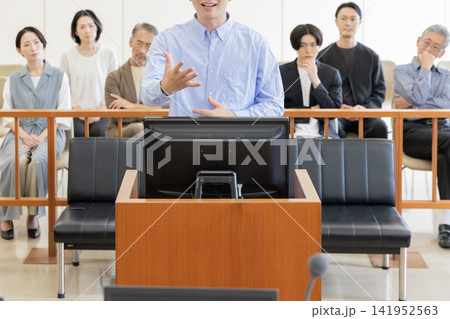 法廷で証言を行う若い男性と裁判を見守る傍聴人 法廷で証言を行う若い男性と裁判を見守る傍聴人 141952563