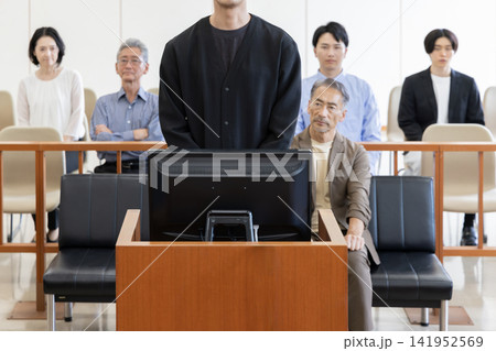 法廷で証言を行う若い男性と裁判を見守る傍聴人 法廷で証言を行う若い男性と裁判を見守る傍聴人 141952569