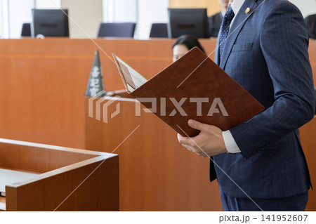 法廷で証人尋問の資料を提示する若手弁護士 法廷で証人尋問の資料を提示する若手弁護士 141952607