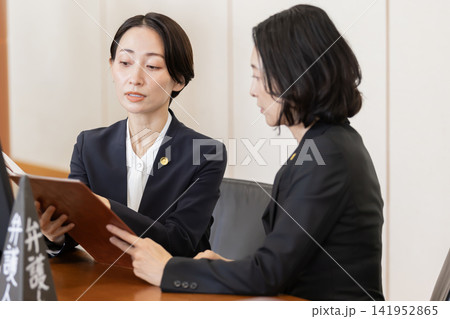 法廷で打ち合わせを行う女性弁護士チーム 141952865