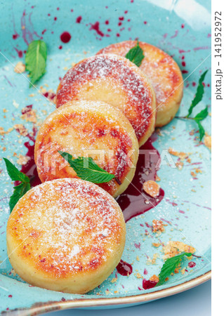 Fried cottage cheese pancakes with powdered sugar on plate Fried cottage cheese pancakes with powdered sugar on plate 141952972