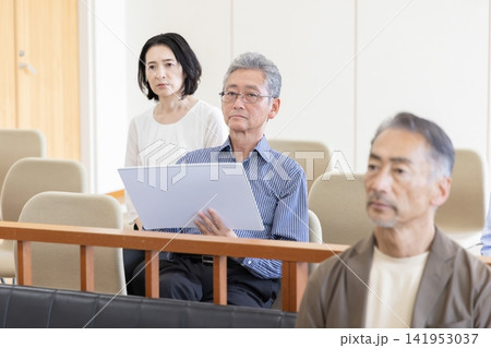 法廷の傍聴席で風刺絵を描きながら裁判を見守る男性 法廷の傍聴席で風刺絵を描きながら裁判を見守る男性 141953037