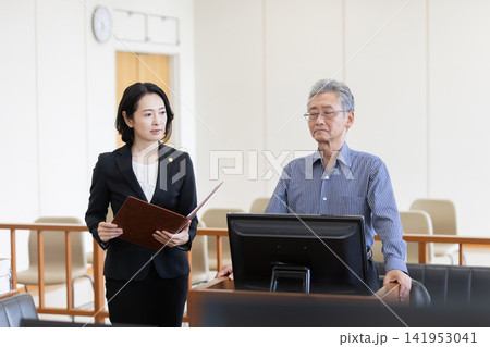 法廷で証言する男性と尋問を行う女性弁護士 法廷で証言する男性と尋問を行う女性弁護士 141953041