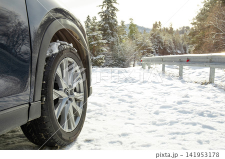 Winter travel. Vehicle parked on snowy road next to guardrail in winter scenery Winter travel. Vehicle parked on snowy road next to guardrail in winter scenery 141953178