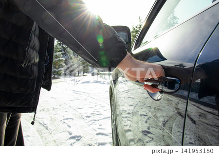Winter travel. Driver approaches vehicle in snowy environment for safe travel Winter travel. Driver approaches vehicle in snowy environment for safe travel 141953180