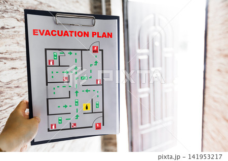 Emergency evacuation plan displayed on wall near exit door 141953217