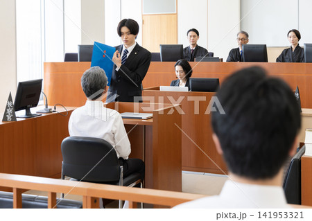 法廷で証拠資料を示しながら証人尋問を行う若い検察官 法廷で証拠資料を示しながら証人尋問を行う若い検察官 141953321