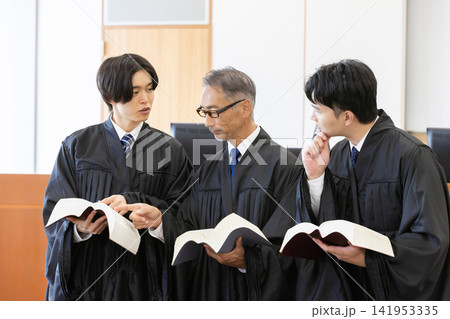 法廷で六法全書を確認しながら打ち合わせをする日本人裁判官3人 法廷で六法全書を確認しながら打ち合わせをする日本人裁判官3人 141953335