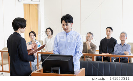 法廷で証言を行う若い男性と裁判を見守る傍聴人 法廷で証言を行う若い男性と裁判を見守る傍聴人 141953511