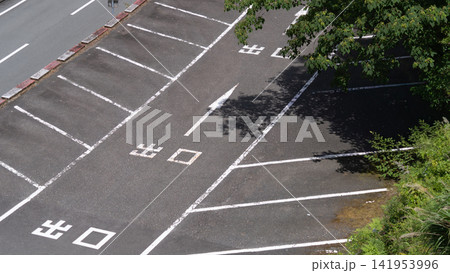出口表示と白線と木の影が広がる無人の駐車場 出口表示と白線と木の影が広がる無人の駐車場 141953996