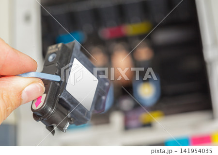 Changing ink cartridge in a printer during a printing process at an office Changing ink cartridge in a printer during a printing process at an office 141954035