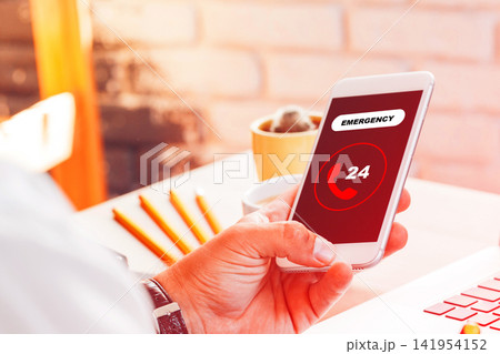 Calling emergency services with a smartphone during a crisis situation in a well-lit indoor setting Calling emergency services with a smartphone during a crisis situation in a well-lit indoor setting 141954152