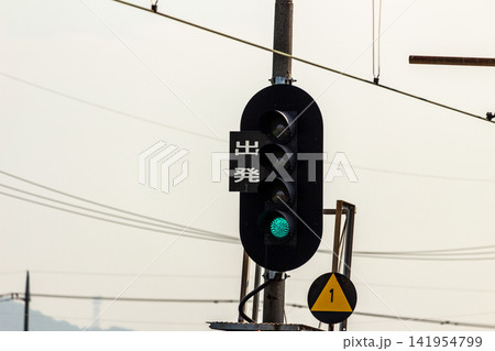青信号が点灯する鉄道の出発信号機(朝の風景・出発・進行のイメージ) 青信号が点灯する鉄道の出発信号機(朝の風景・出発・進行のイメージ) 141954799