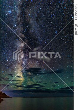 積丹半島の窓岩と夜空にそびえる天の川の銀河をかすめるペルセウス座流星群 積丹半島の窓岩と夜空にそびえる天の川の銀河をかすめるペルセウス座流星群 141954849