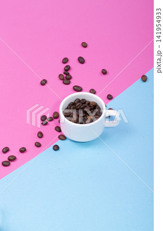 Cup with coffee beans on a colored background Cup with coffee beans on a colored background 141954933