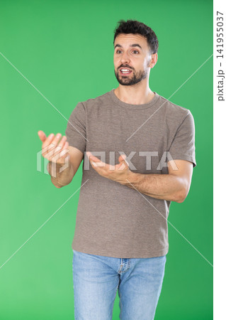 European man on green screen background speaks or addresses imaginary partner. 141955037