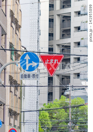 市街地に設置された止まれ標識と指定方向標識 141955899