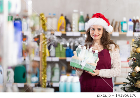 Woman seller in Santa hat presents festive set of shower cosmetics 141956170