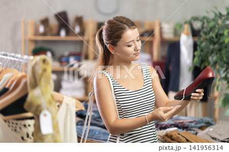 Young woman choosing shoes in store Young woman choosing shoes in store 141956314